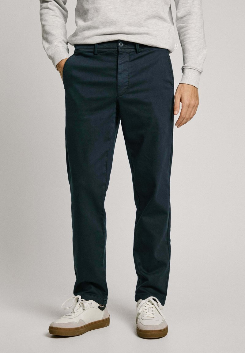 Navy blue cotton trousers with a relaxed fit, featuring a button and zipper closure, two side pockets, and a smooth texture.