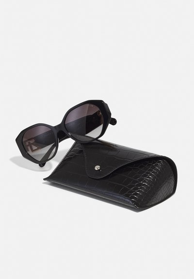 Black octagonal sunglasses with gradient lenses, accompanied by a black crocodile-textured case featuring a snap closure.