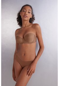 Bruine strapless beha en bijpassende slip gemaakt van gladde stof, met een naadloos ontwerp en minimalistische snit.