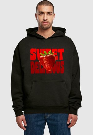 Black hoodie featuring a graphic of a strawberry and the text "SWEET DELICIOUS" in bold red. Material appears soft; kangaroo pocket visible.