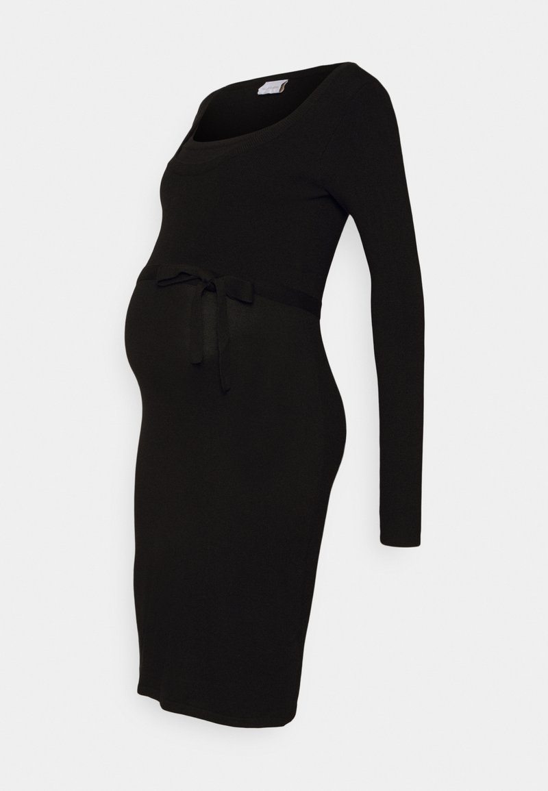 Robe de maternité noire à manches longues, longueur genoux, avec un décolleté rond et une ceinture nouée au-dessus du ventre, sur fond uni.