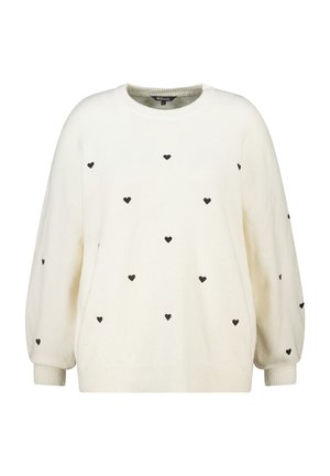 Crème-kleurige sweater gemaakt van zachte stof, met een losse fit en zwarte hartpatronen verspreid over het geheel. Rond de hals en geribbelde manchetten.