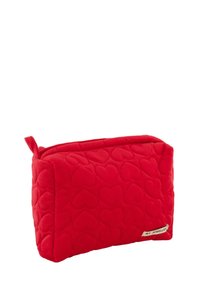 Rode gewatteerde toilettas met hartjespatroon, rechthoekige vorm, zachte textuur en een zijrits. Kenmerkt zich door een klein label met de tekst "MIJN JUWELIER."