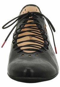 Chaussure en cuir noir avec une surface texturée, dotée d'un bout rond, de lacets noirs et d'accents rouges aux extrémités. Détails perforés près de la languette.