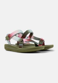 Strappy sandals feature a mix of pink, mint, and olive green fabric straps on a green cushioned sole. Adjustable buckle for fit.