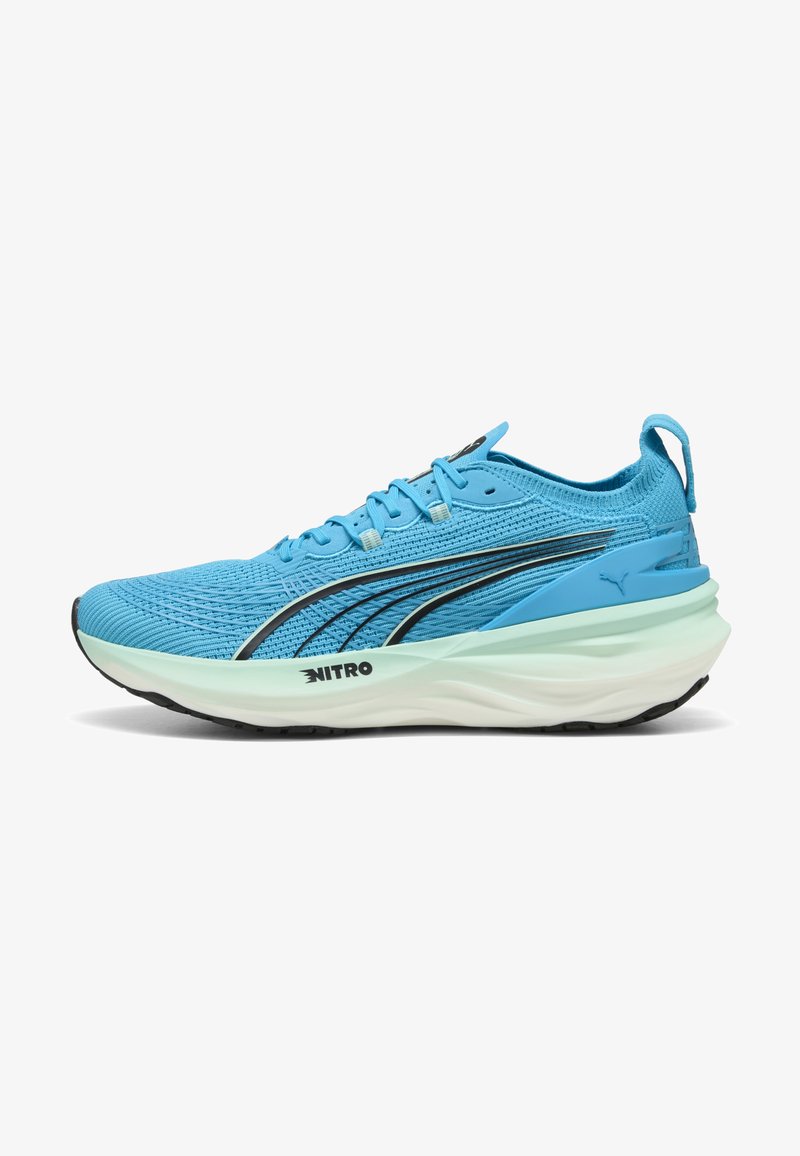 Scarpe da corsa azzurro chiaro con una tomaia in mesh testurizzato, dettagli neri, suola bianca ammortizzata e un occhiello sul tallone per facilitarne l'indossamento.