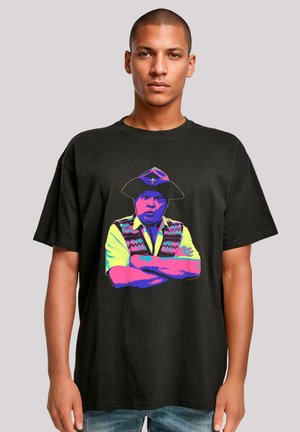 Black cotton t-shirt featuring a vibrant, multicolored graphic of a man wearing a hat and a vest, arms crossed.