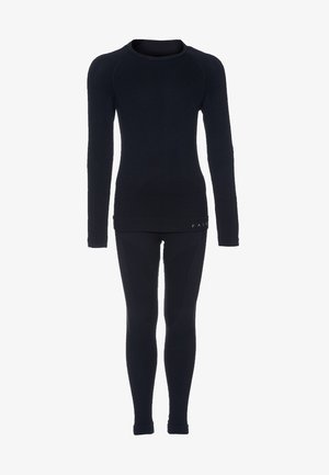 Maglietta termica nera a maniche lunghe con scollo rotondo e maniche lunghe, abbinata a leggings termici neri aderenti. Realizzata in tessuto liscio ed elastico.