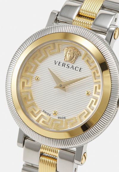 Versace laikrodis su sidabro ir aukso nerūdijančio plieno apyranke, tekstūruota sidabro ciferblatas su graikų rakto raštu ir Medūzos akcentu. Pagaminta Šveicarijoje.