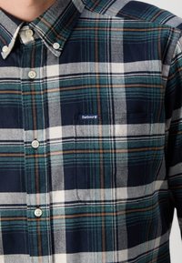 Chemise boutonnée pour hommes à carreaux verts, bleu marine, blancs et marron, avec col boutonné et poche poitrine étiquetée "Barbour".