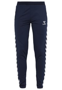 Marineblaue Sporthosen mit engem Schnitt, ausgestattet mit einem schwarzen Bund und weißen Chevronstreifen an den Seiten. Logo auf dem Oberschenkel.