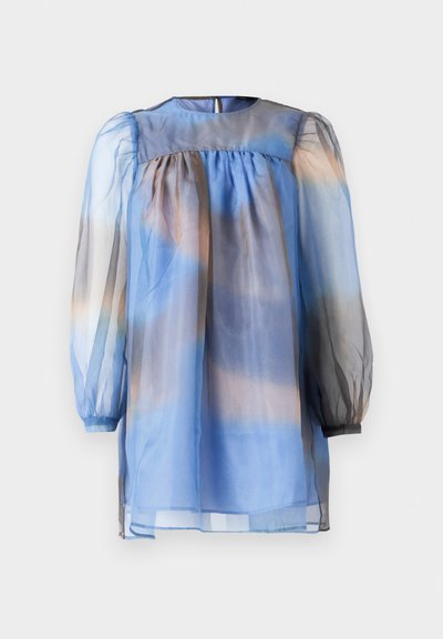 Prozirna plava bluzica s okruglim izrezom i napuhanim rukavima. Karakterizira je gradijent plavih do bež tonova i nabira se na razini poprsja.