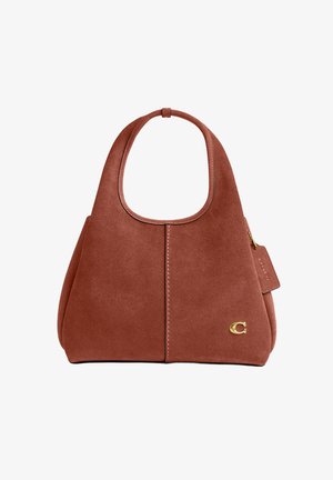 Barna színű, velúr kézitáska széles fogantyúval, lekerekített téglalap alakú, középen varrással, és az alsó jobb oldalon egy kis arany "C" logóval.