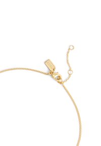 Gold chain bracelet with a lobster clasp and adjustable chain. Features a rectangular tag with engraving. Smooth texture and shiny finish.