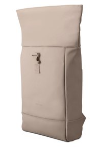 Beige színű, roll-top hátizsák sima anyagból, elülső hevederrel záródik, és strukturált kialakítással rendelkezik. Minimalista forma, diszkrét márkalogóval.
