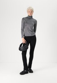 Pelēks, garām piedurknēm, kaklā aptīts tops, melni pieguļoši bikses un melna rokassoma. Apģērbu papildina melni apavi ar teksturētu materiālu. Vienkārša, moderna stilistika.