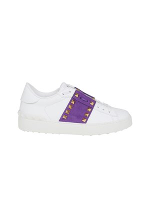 Sneaker bianca basse con cinturino in suede viola con borchie piramidali dorate e suola in gomma bianca.
