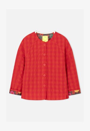 Punase ruudulise mustriga tikitud jakk pikkade varrukatega, ümar kaelus ja viie nööbiga kinnitusega. Varruka mansettidel lillemustriline ääris.