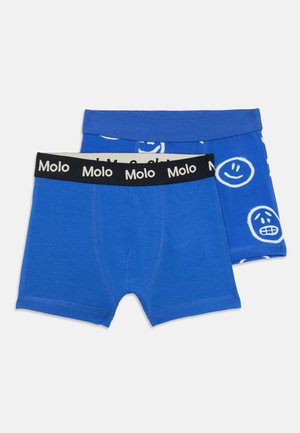 Dve sady modrých chlapčenských boxeriek. Jedny sú jednofarebné modré; druhé majú vzor s bielymi smajlíkmi. Obe majú čierne elastické pásky s textom "Molo".
