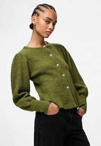 Zielony sweter kardigan z długimi bufiastymi rękawami, pięcioma dekoracyjnymi srebrnymi guzikami i okrągłym dekoltem. Teksturowany materiał dodaje wizualnej głębi.