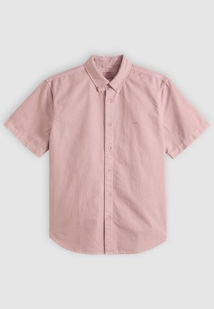 Camisa de manga corta de color rosa claro con botones, cuello abotonado, botones en el frente y costuras sutiles sobre un fondo liso.