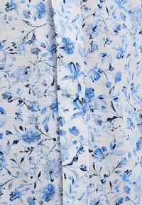 Blumiges Hemd mit Knopfverschluss, das einen weißen Hintergrund mit blauen und schwarzen Blumenmustern, eine weiche Textur und ein einzelnes weißes Knopfdetail aufweist.