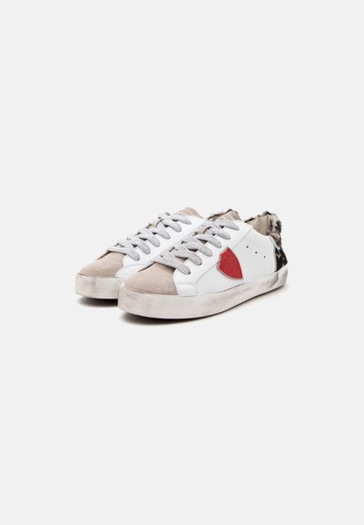 Λευκά sneakers χαμηλού προφίλ με γκρι κορδόνια, μπεζ άκρες στα δάχτυλα, κόκκινο patch στα πλαϊνά και ασπρόμαυρο animal print στη φτέρνα.