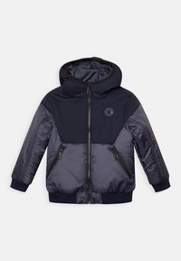 Marinblå vadderad jacka med huva, dragkedjestängning, två fickor med dragkedja, ribbade ärmslut och en cirkulär logotyp på bröstet. Slätt, lättviktigt material.