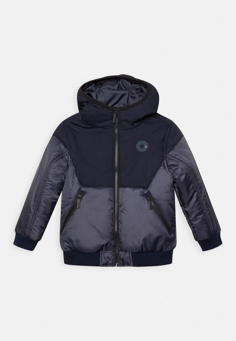 Marinblå vadderad jacka med huva, dragkedjestängning, två fickor med dragkedja, ribbade ärmslut och en cirkulär logotyp på bröstet. Slätt, lättviktigt material.