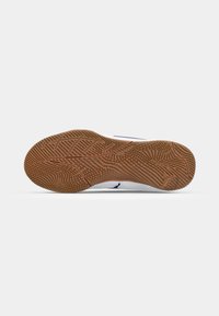 Sports shoe with a white upper, blue accents, and a textured brown rubber sole featuring a patterned design for traction.
