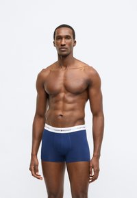 Marineblå bomuldsboxershorts med hvid elastisk talje med "Tommy Hilfiger"-logo. Behagelig pasform med glat tekstur.