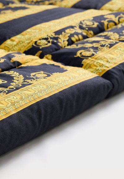 Couverture en tissu bleu marine ornée de motifs floraux et géométriques en orintriqués. Le design comprend de larges bandes décoratives et une texture douce.