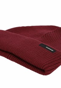 Gorro de punto burdeos con un dobladillo doblado y una etiqueta de marca negra. Textura acanalada con un diseño ajustado.