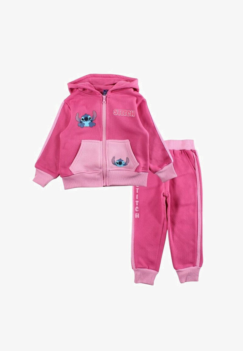 Sweat à capuche rose avec une fermeture éclair sur le devant, comprenant des motifs de Stitch et des poches. Pantalon assorti avec des chevilles resserrées, tous deux fabriqués en tissu doux.