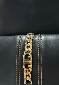 Borsa a mano in pelle nera con tracolla in catena dorata, caratterizzata da un distintivo accento hardware. Decorata con cuciture marroni lungo le cuciture.