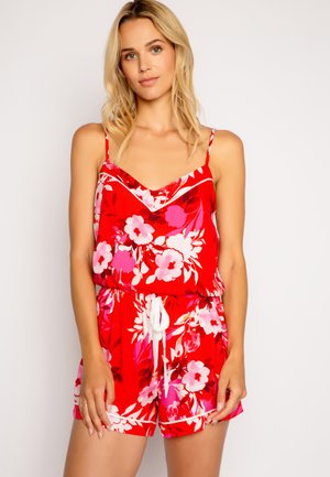 Röd blommig jumpsuit med V-ringning, spagettiband, elastisk midja med dragsko och vita detaljer på ärmarna och shortsen.