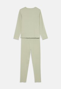 Soft light green ribbed long-sleeve top and matching high-waisted leggings set with lettuce-edge hems on sleeves, waist, and ankles.