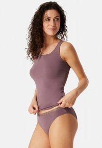 Lilla topp sangade kaelusega ja pitsäärisega, millele on lisatud sobivad pitsäärega pesu. Sile kangas, keha ümberistuv lõige.