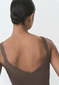 Brown sleeveless top with a deep V-cut back. Smooth, textured fabric with shiny accents, highlighting the shoulders. Hair styled in a bun.