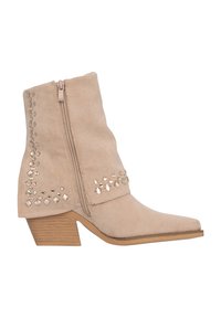 Botas de tobillo de ante beige con punta afilada, cremallera lateral y tachuelas decorativas plateadas en el lado exterior. Tacón apilado, superficie texturizada.