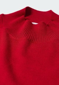 Pull rouge à côtes avec un col haut, présentant une texture douce et un léger éclat. L'encolure a un détail de découpe unique.