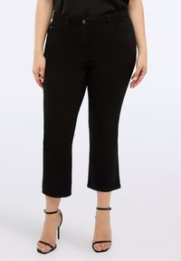 Černé zkrácené džíny s hladkou texturou, mající klasický pětikapsový design, zapínání na knoflík a mírnou pružnost pro pohodlí.