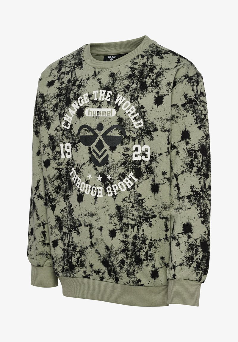 Sweat-shirt vert olive avec un motif abstrait noir, col rond, poignets côtelés, et une impression graphique blanche portant la mention "CHANGE THE WORLD 1923 THROUGH SPORT."