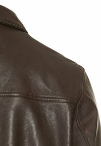 Bruine leren jas, schouderzicht. Glad textuur, klassieke kraag, gestikte details en een licht glanzende afwerking.