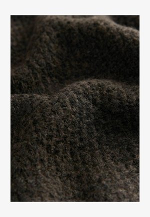 Tissu marron foncé, texturé avec une apparence douce et duveteuse. Le matériau présente un motif tricoté, ajoutant de la profondeur à la surface.