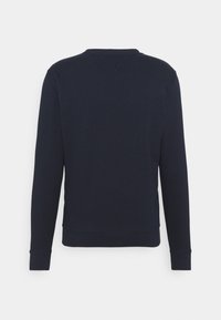 Sweat-shirt à manches longues bleu marine avec col rond, poignets et ceinture côtelés, vu de dos sur un fond uni.