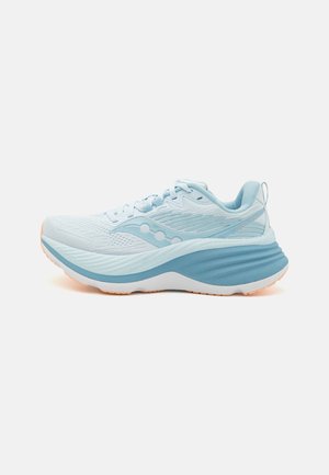 Scarpa da corsa azzurro chiaro con design in rete, sovrapposizioni testurizzate, ammortizzazione bianca spessa e sottili accenti arancioni sulla suola.
