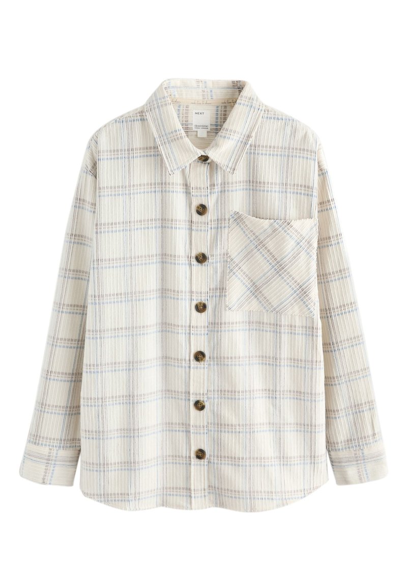 Košile s dlouhými rukávy v krémové barvě s modrými a hnědými pruhy. Má dřevěné knoflíky a kapsu na hrudi s diagonálním vzorem.