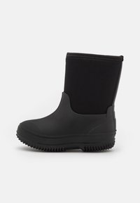 Botín negro impermeable hasta el tobillo, con una sección inferior de goma y parte superior de tela suave, que cuenta con una suela texturizada antideslizante y un puño elástico.