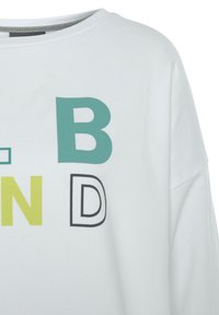 White short-sleeve shirt featuring bold, colorful letters in teal, yellow, black, and grey. Soft fabric with a round neckline.